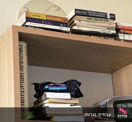 מדף עץ עם ספרים וחפצים שונים